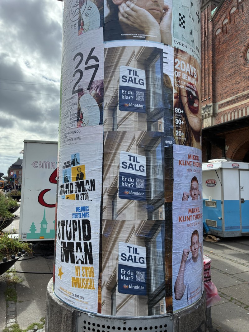 Låneklars plakater tæt på, side om side med byens andre plakater