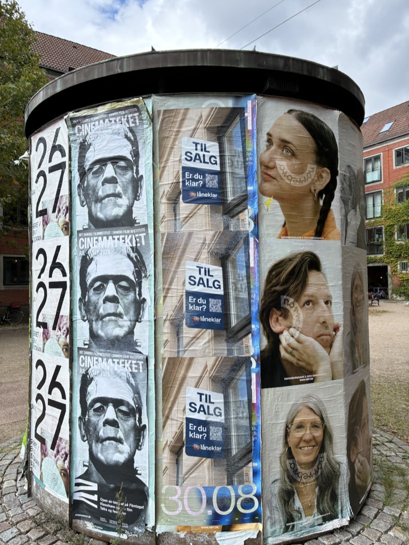 En plakatsøjle ved en gade med Låneklars plakater